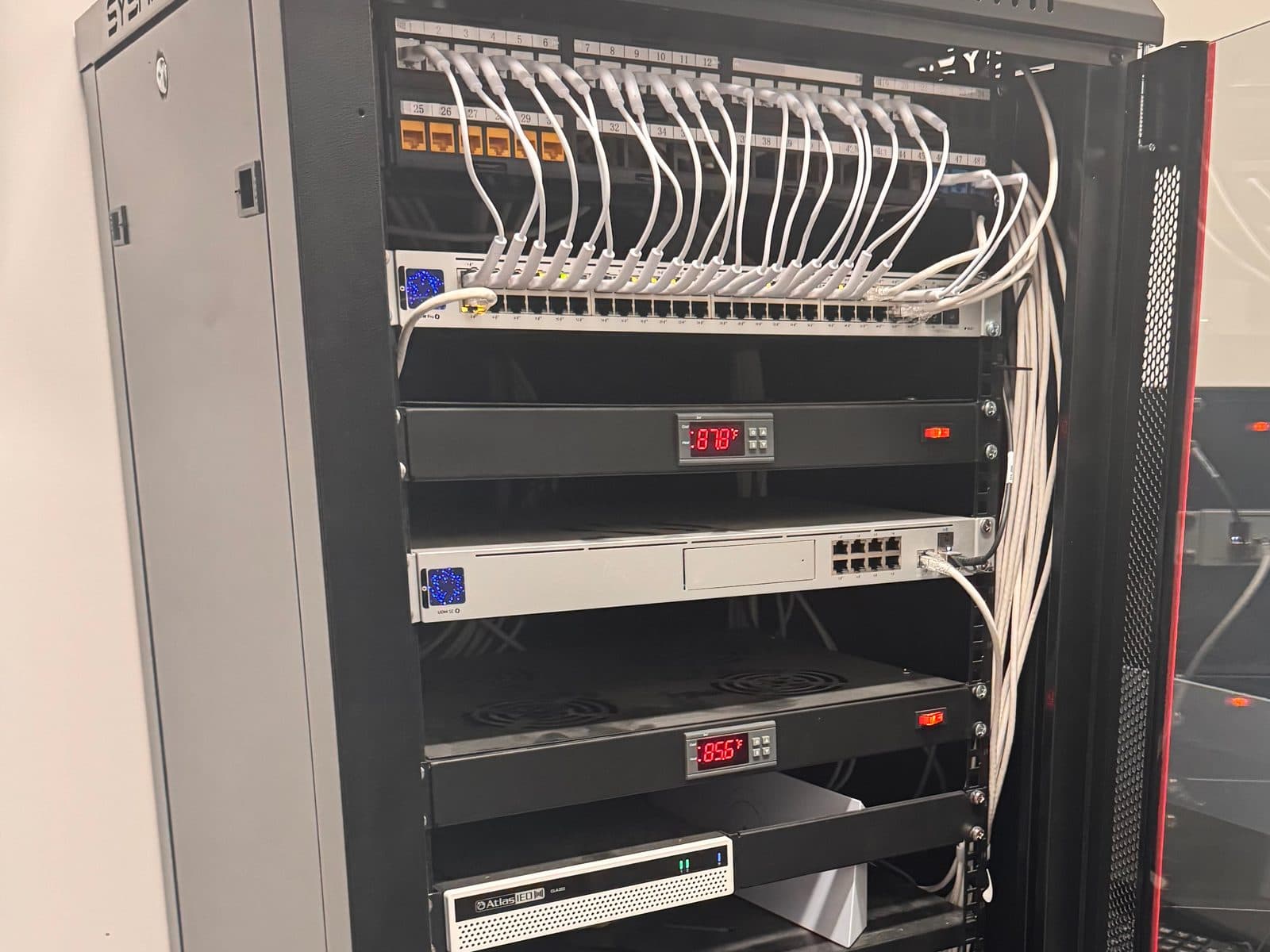 Dressed patch panel and UniFi switch in a wall-mount network rack